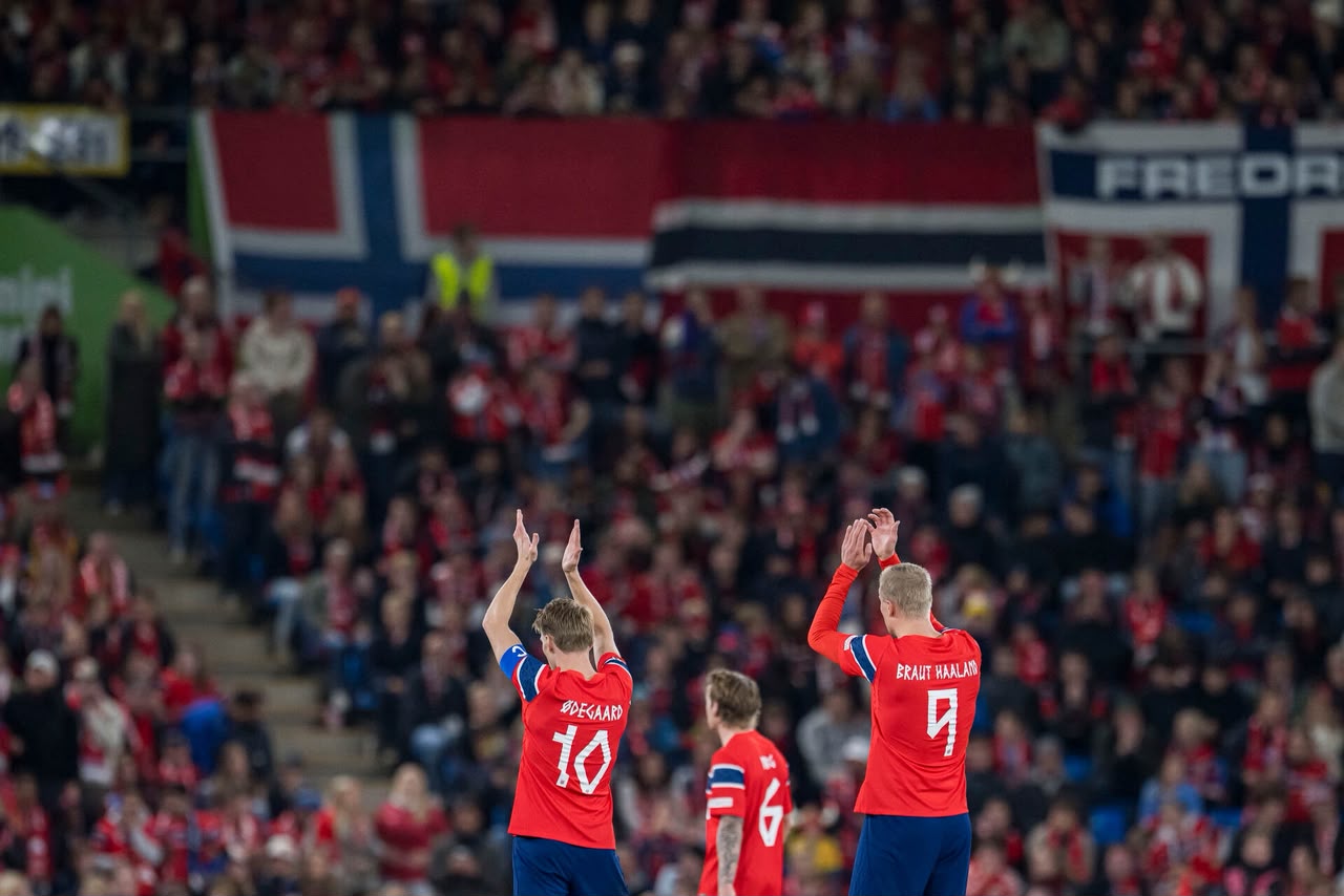 Martin Ødegaard and Erling Haaland applaud Norwegian supporters after an international match