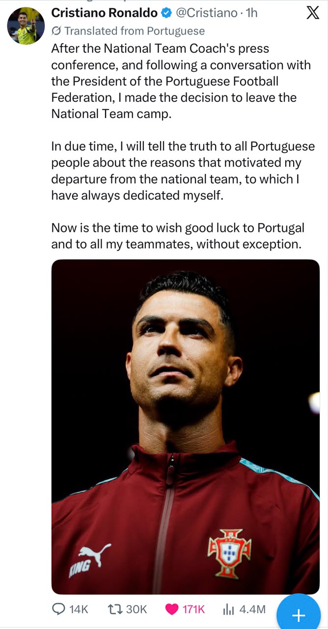 A close-up portrait of Cristiano Ronaldo looking upward in a reflective pose, wearing a maroon and teal Portugal national football team training jacket with the FPF crest and Puma logo