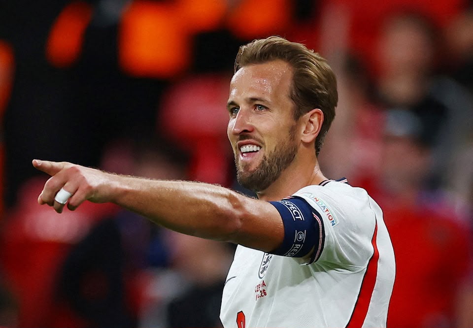 England captain Harry Kane smiling and pointing during a match at Wembley Stadium.